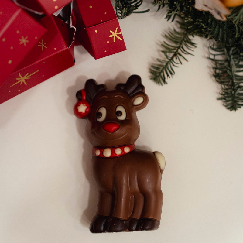 Chocolate reindeer figurine with Christmas decorations in the background